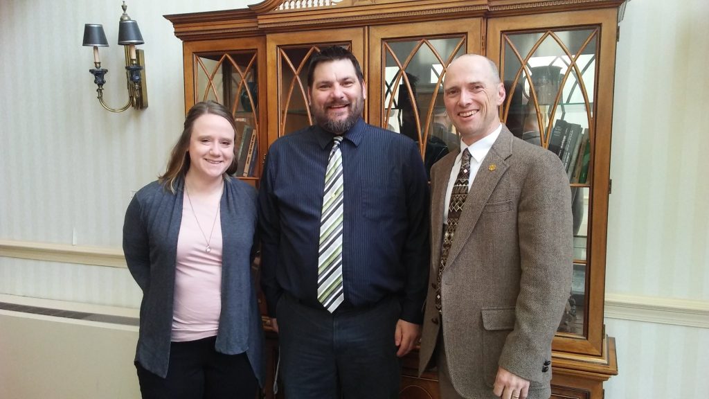 Three people posed in the hallway